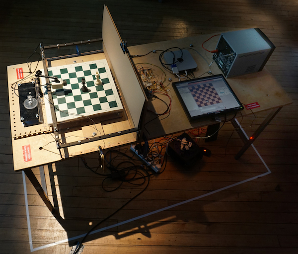 Correspondence, 2019:  installation view Motorised chess board, cctv camera, video monitor,customized circuits and software, electromagnets, python script linked to public chess forum